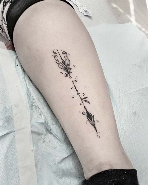 Forearm tattoo of an arrow crossing the word