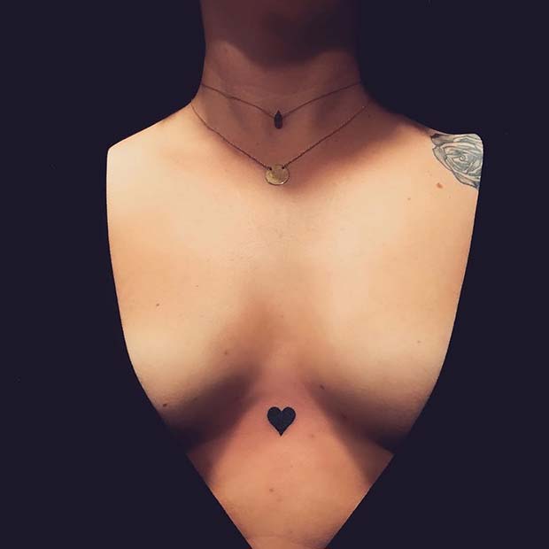 Minimalistic red heart tattoo located on the shoulder