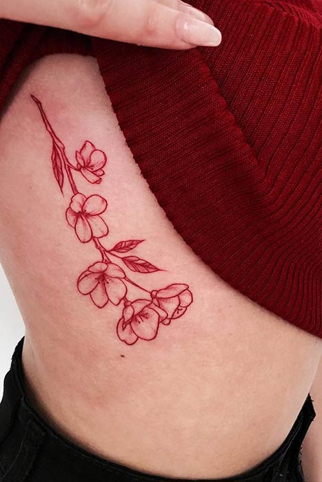 Red ink rose tattoo on the right inner arm