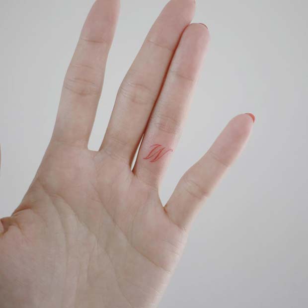 Minimalist red heart tattoo on the finger