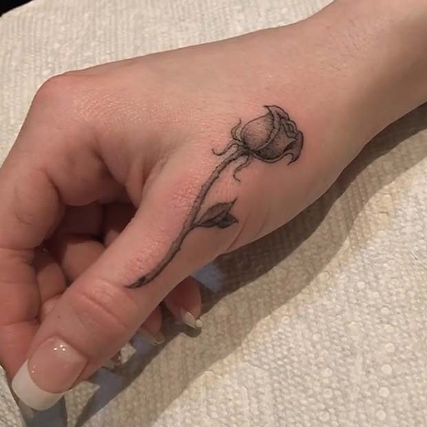 Black and grey shaded rose couple tattoo below right upper thumb